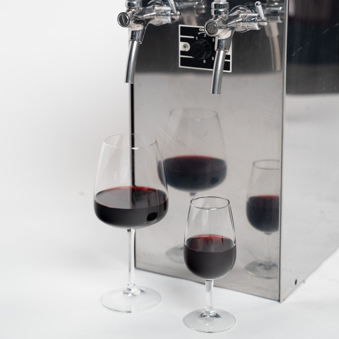 Vinboks til udskænkning med 2 haner, 2 glas rødvin halvfyldte foran